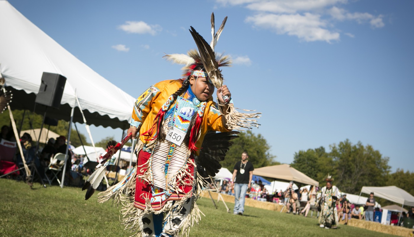 Traditional Native American dancing, food and vendors in an outdoor environment.
