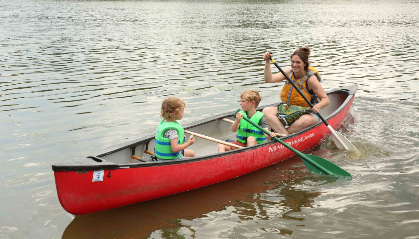 A family on the water in a canoe.