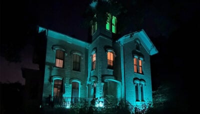 A photo of Trailside Museum at night, illuminated with spooky lighting for the Halloween season.