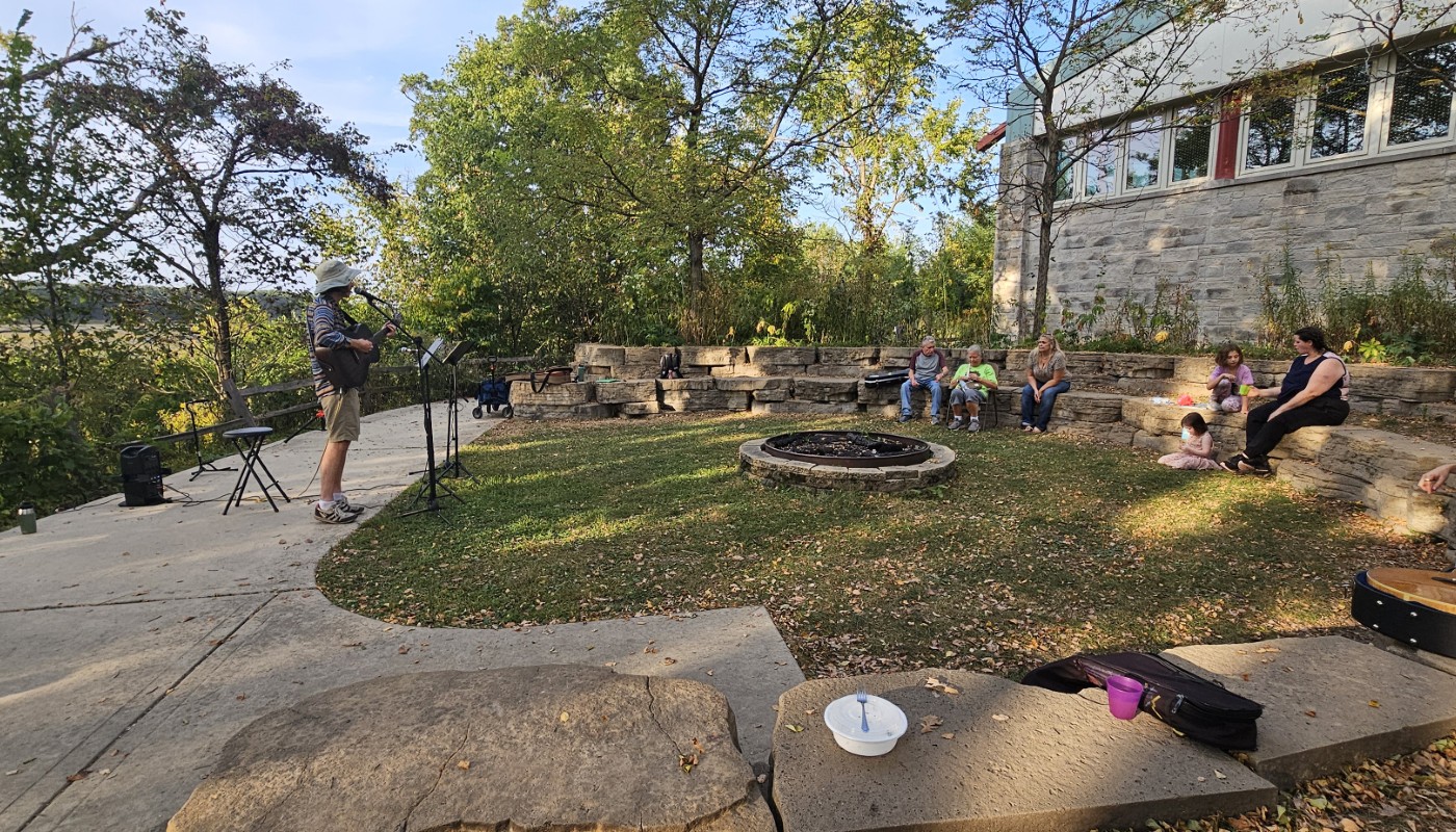 A musician playing a guitar outdoors.