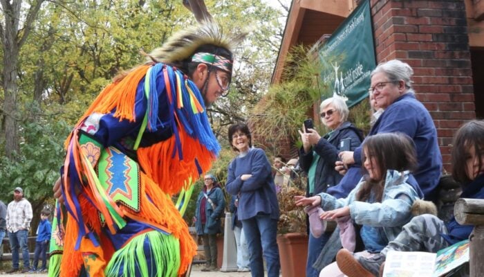 A performer and a group of children outside.