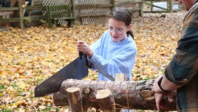 A child outdoors during a demonstration with staff.