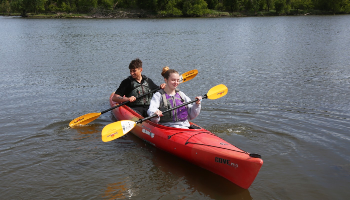 Two people paddling in a large body of water.