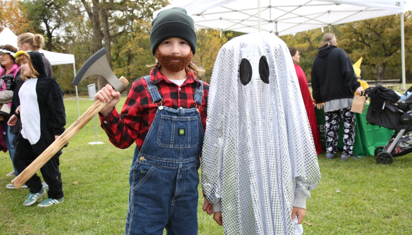 Children wearing Halloween costumes outdoors.