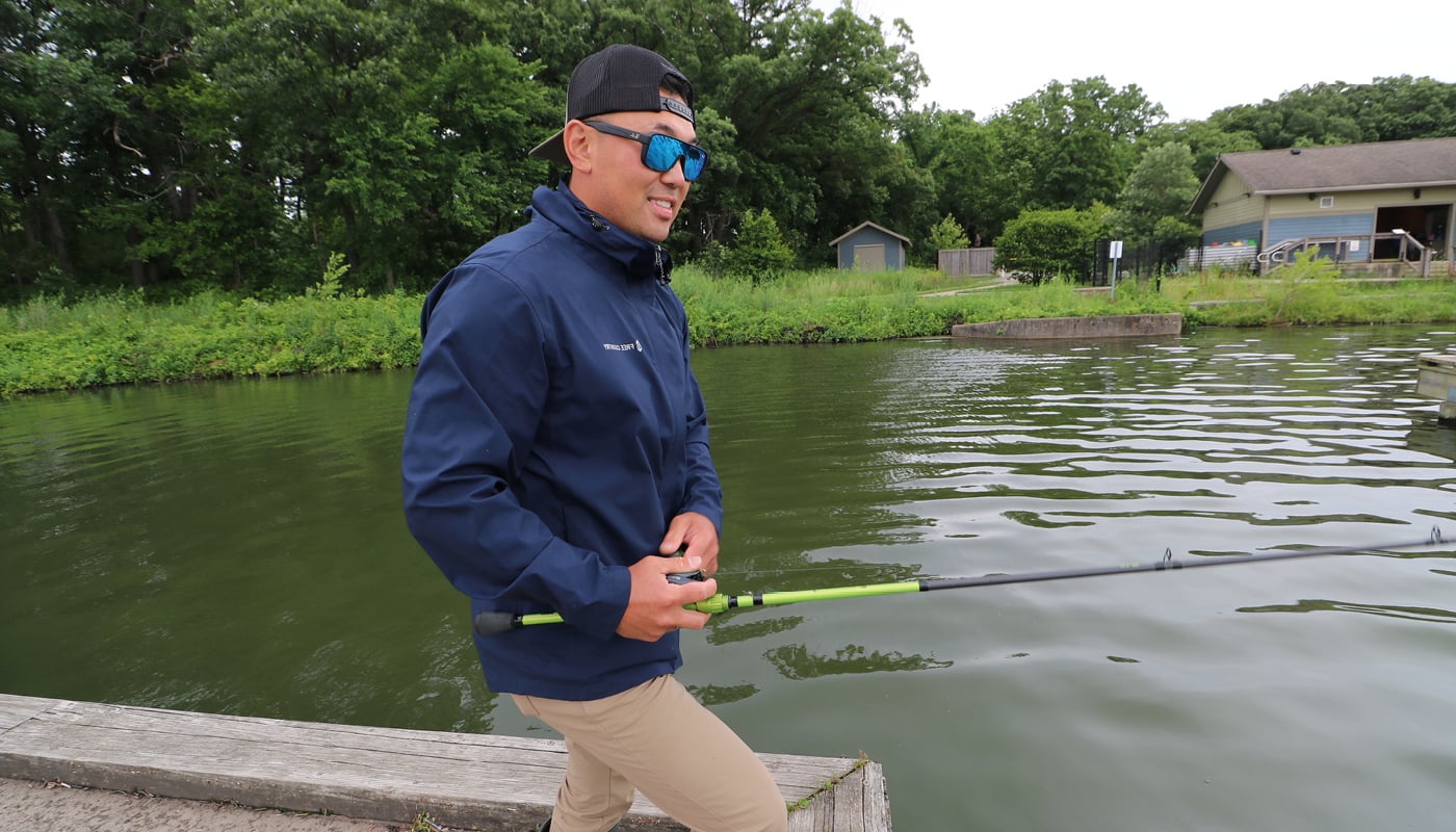 A man standing by the water with a fishing pole.