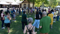 A group of people form a circle on the grass.