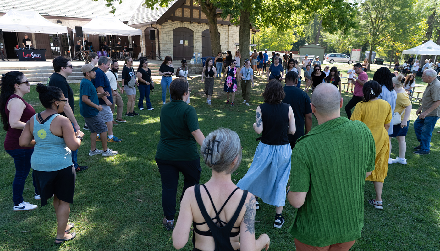 A group of people form a circle on the grass.